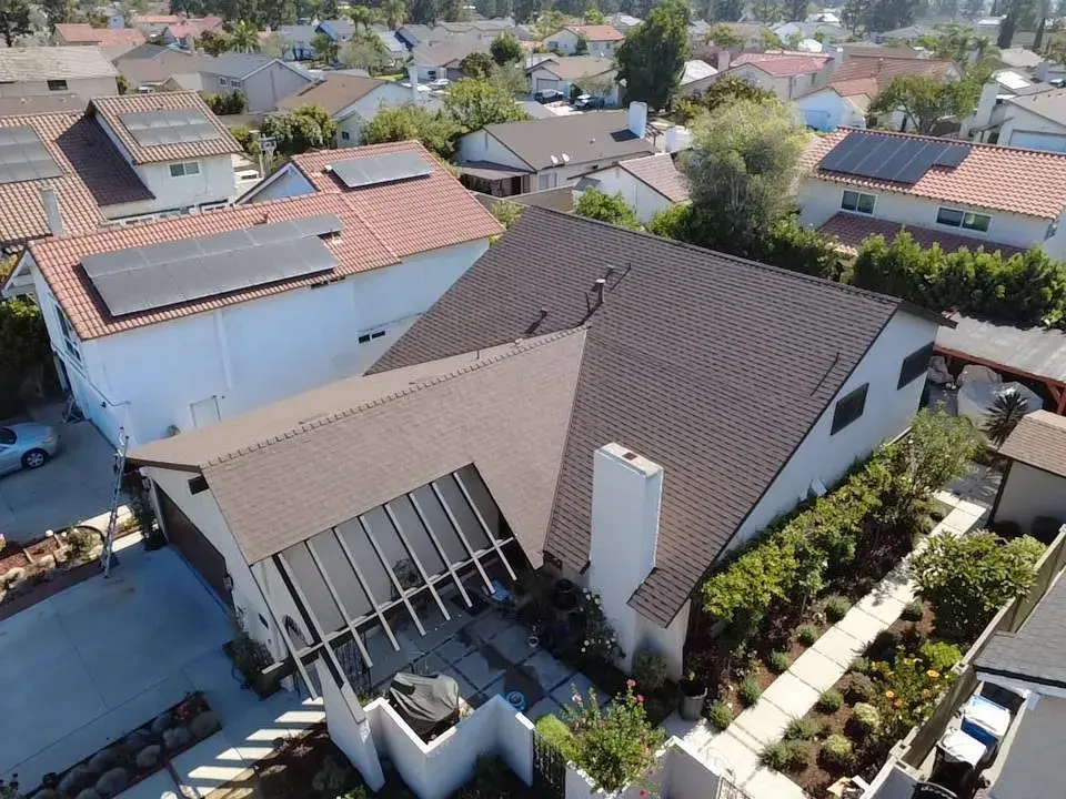 Aerial view of a brown shingle hip roof on a two-story home
