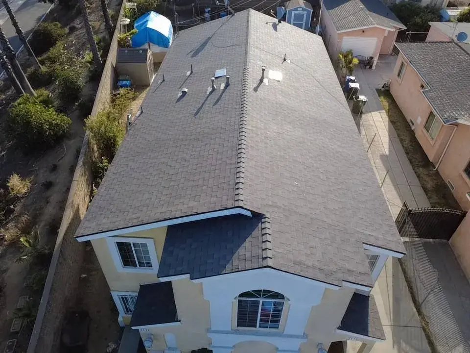 Aerial view of a gray shingle roof on a two-story home with a garage