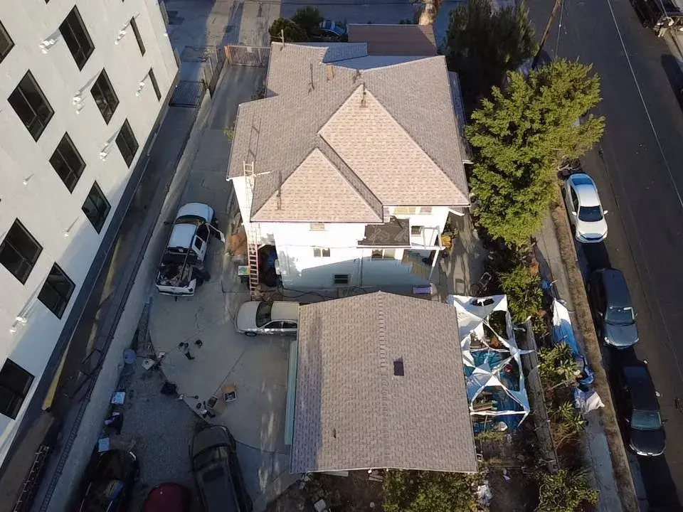 Aerial view of a two-story home with a brown shingle roof