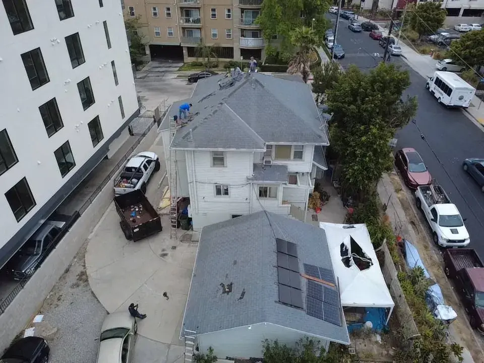 Aerial view of homes with shingle roofs and rooftop solar panels
