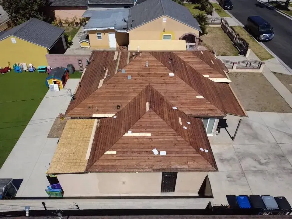 Aerial view of a hip roof with new plywood decking during a re-roof