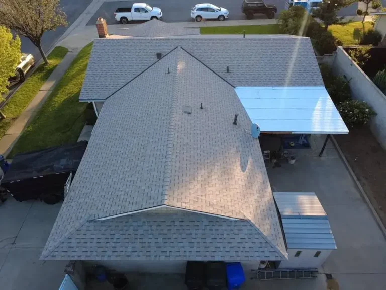 Aerial view of a new gray shingle roof and a flat patio cover