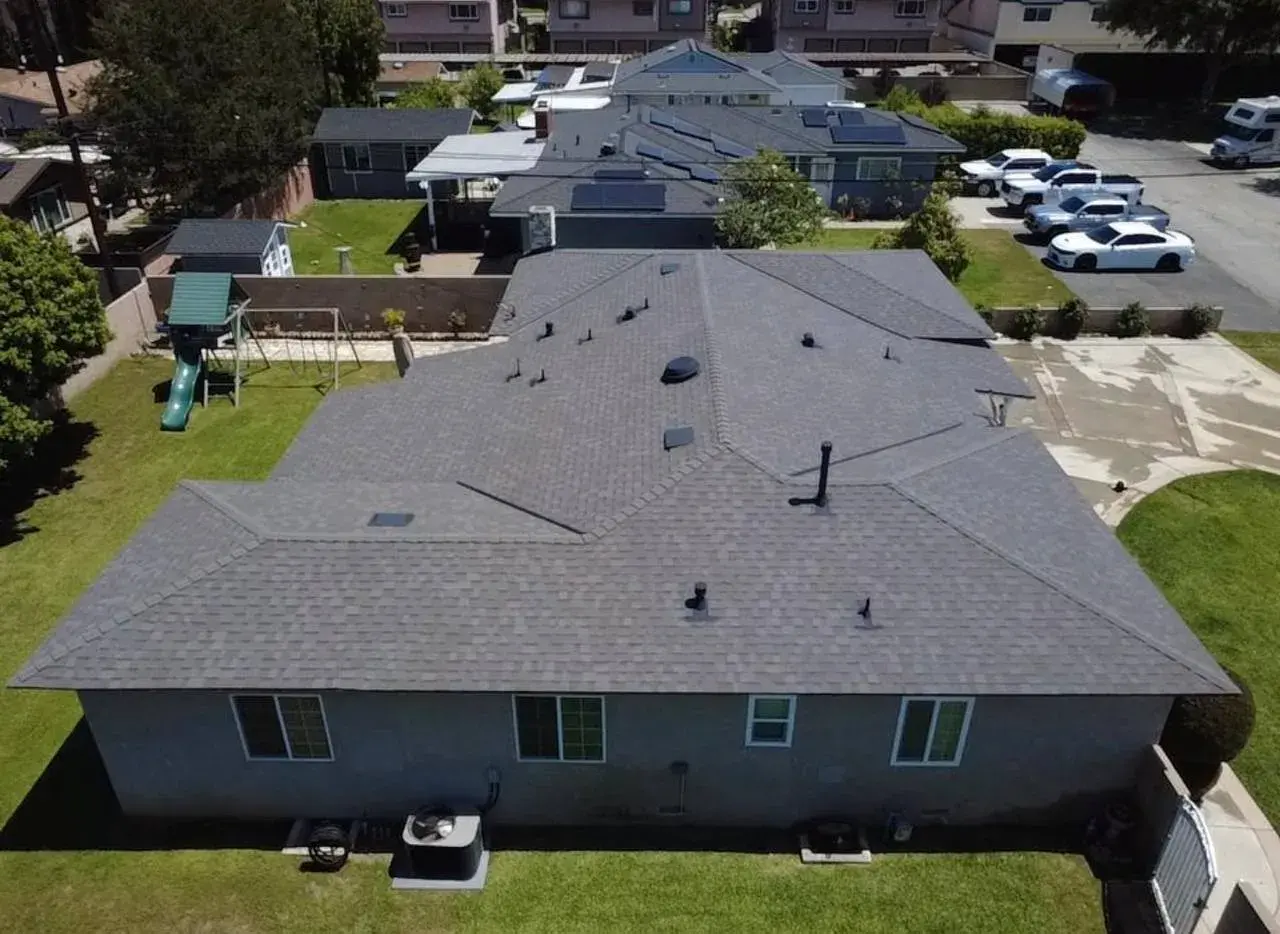 Aerial view of a new dark gray shingle roof on a single-story home