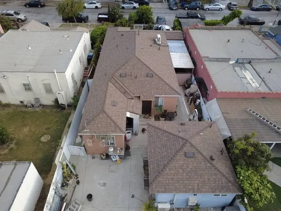 Aerial view of brown asphalt shingle roofs on neighboring homes