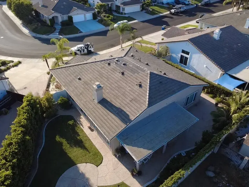 Aerial view of a gray shingle roof on a single-story home with a pool