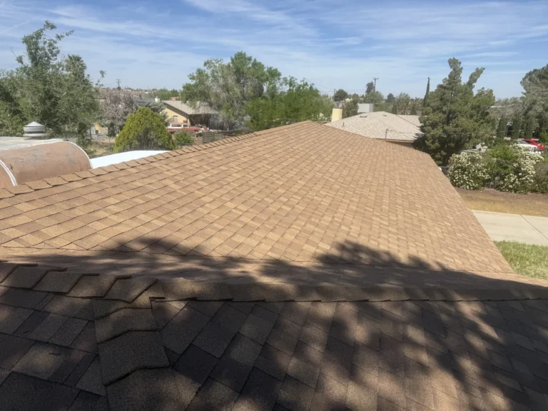 New brown shingle roof on a hip roof with trees and a park in the background