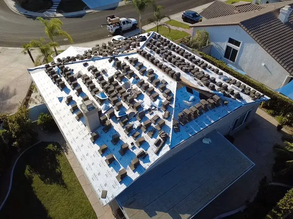 Roof tiles stacked on new underlayment during a tile re-roof